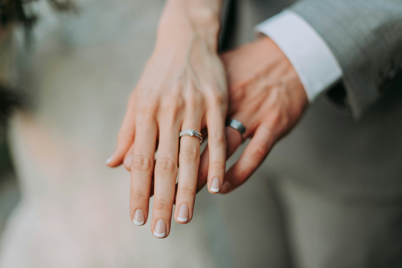 A couple holding hands, showing their wedding rings